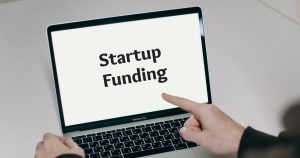A founder researching startup funding stages on a laptop to plan their venture's capital strategy.