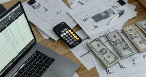 Laptop and cash on desk working cash flow management